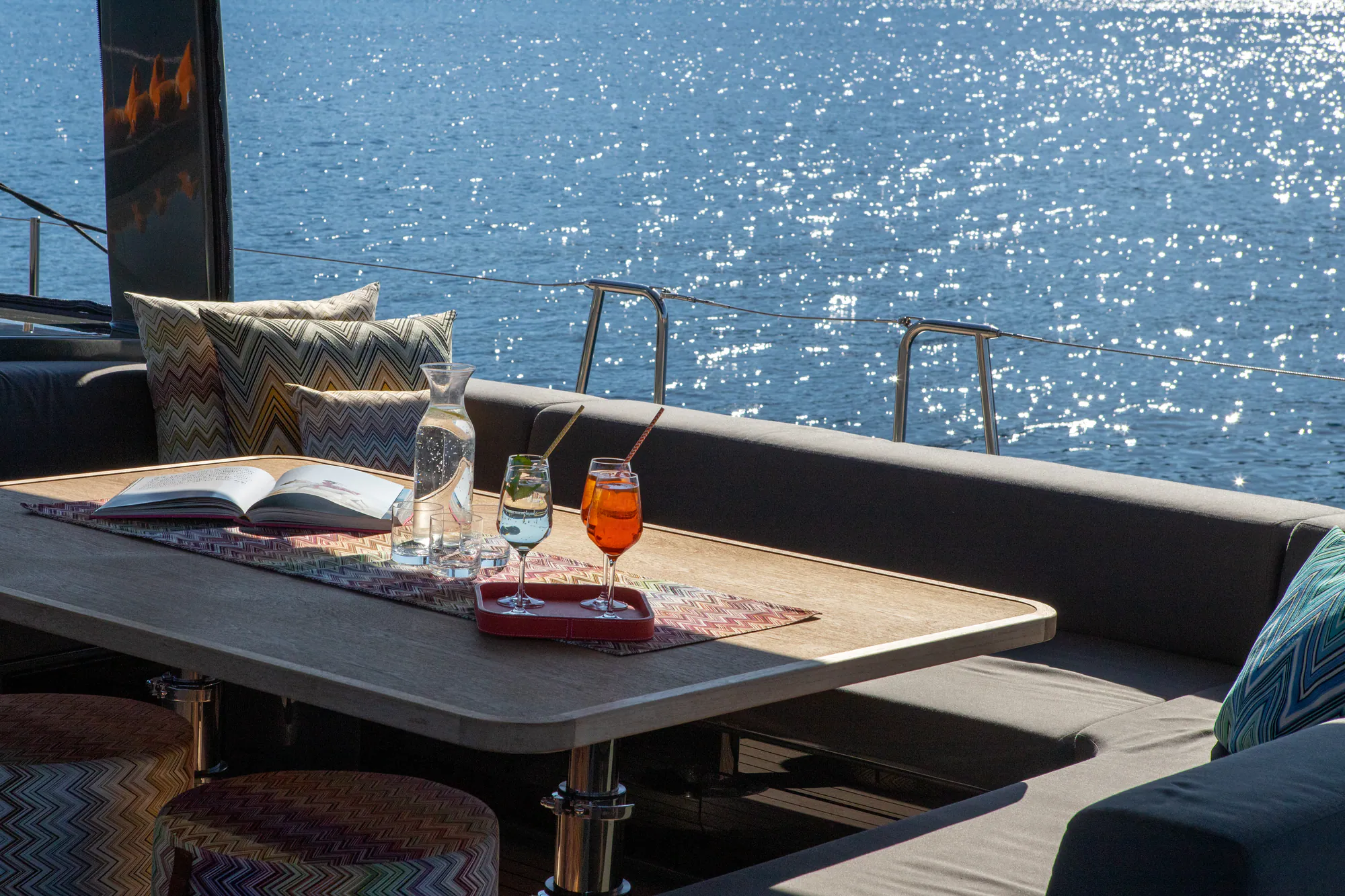 Aperitifs served at the cockpit table aboard Sailing Yacht W, sunlight on the water beyond
