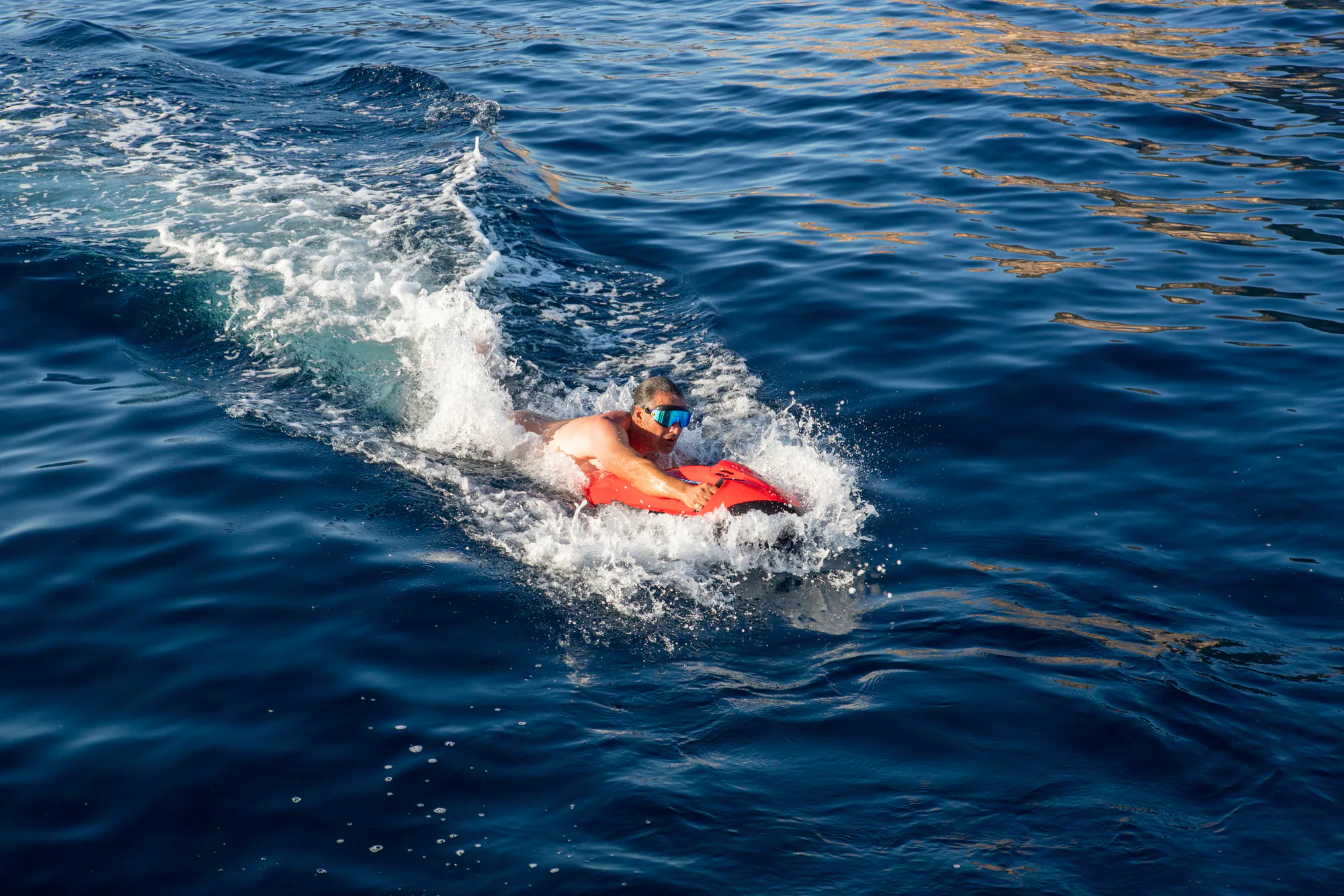 A guest swimming in the clear Mediterranean beside Sailing Yacht W